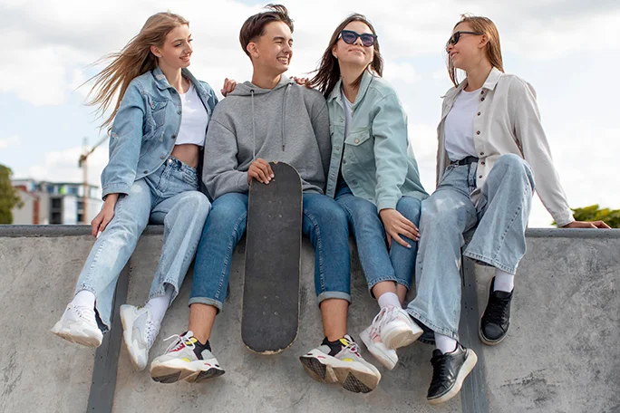 Grupo de amigos pasando tiempo de calidad juntos al aire libre vistiendo la moda demin de Parada111